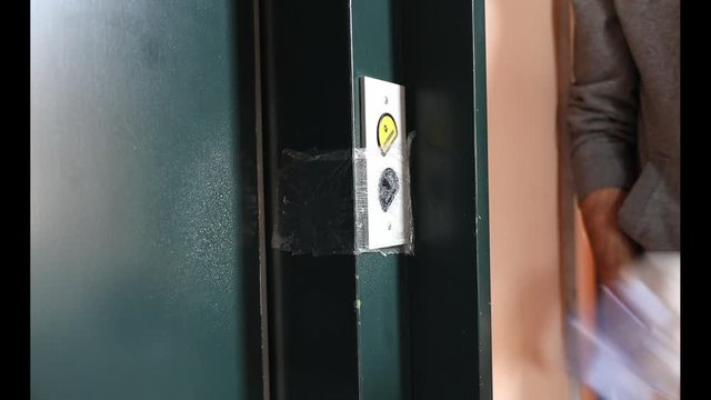 Cleaning staff Cleaned elevator switch button in hospital with alcohol spray and wipe out with clean paper. Corona Virus or bacteria infected protection from touch public object.