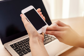 Smartphone screen cleaning with a microfiber wipe and antiseptic liquid