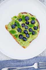 avocado toast with berries and mint on a dish