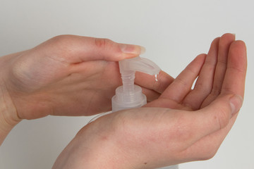 Close-up of woman using hand sanitizer, white background