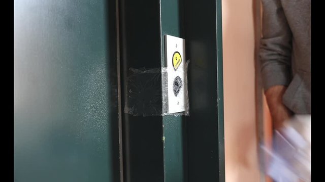 Cleaning staff Cleaned elevator switch button in hospital with alcohol spray and wipe out with clean paper. Corona Virus or bacteria infected protection from touch public object.
