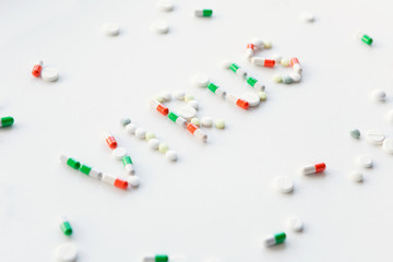 Words in English NCov and Virus made from multi-colored pills on white background. Pharmacological...
