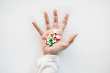 Multicolored pills in hands of man on white background. Pharmacological and health protection concept.