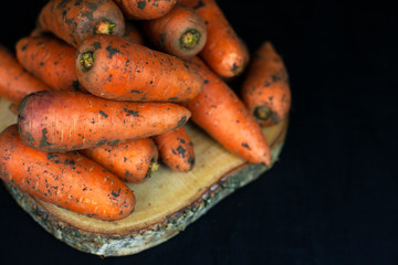 Fresh carrots on a black background, farm organic vegetables
