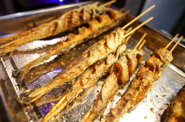 Grilled fish on wooden sticks.