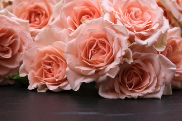 Fresh pink roses on a black background made of natural stone. Copy space