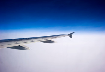 Fototapeta na wymiar wing of airplane flying above clouds
