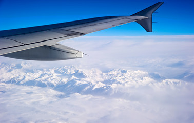 Naklejka na ściany i meble wing of airplane flying above clouds