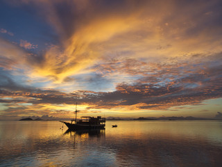 Fototapeta na wymiar Sunrise over a tourist boat near Manta Point, Indonesia