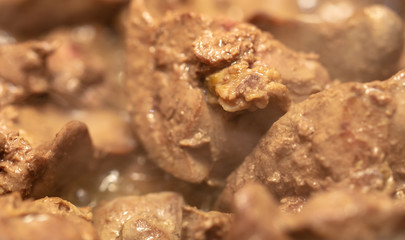 Chicken liver is fried in a pan.