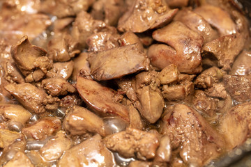 Chicken liver is fried in a pan.