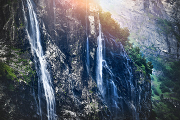 Fototapeta na wymiar Panoramic beautiful deep forest waterfall in norway near blue ocean. Waterfalls mountain view close up.