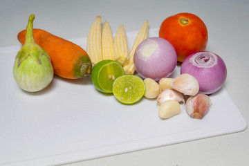 Set of bright vegetables around on white cutting board. Free space for text