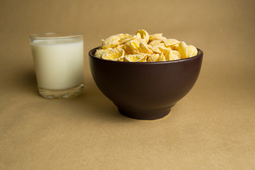 Flakes in a clay bowl and a glass of milk