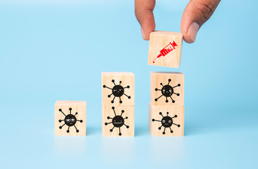 Man hand hold wooden cube Syringe vaccine on corona virus blue background concept for Coronavirus pandemic disease, COVID-19 virus from epidemic outbreak to wide concept for social scientist vaccine