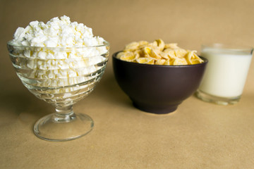 Flakes in a clay bowl, cottage cheese and a glass of milk