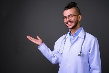 Portrait of happy bearded Turkish man doctor showing something