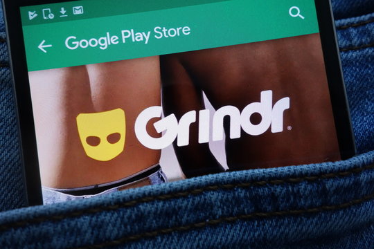 KONSKIE, POLAND - JUNE 11, 2018: Grindr app on Google Play Store website displayed on smartphone hidden in jeans pocket