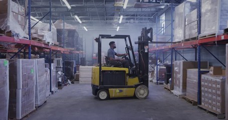 Manager in shipping warehouse using forklift - Powered by Adobe