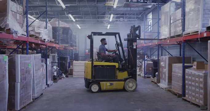 Manager in shipping warehouse using forklift