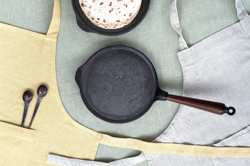 Сast iron pans and spoons, flat bread, linen aprons.