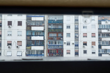 Apartments exterior seen from a window of a building across it in a snowy day