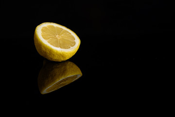 yellow lemon on a black mirror background