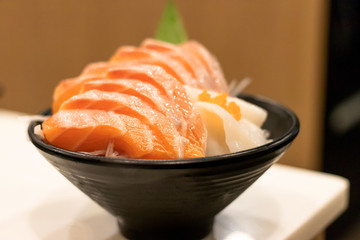 Japanese sashimi sushi set serve on ice with warm light at japanese restaurant. (Salmon and squid)
