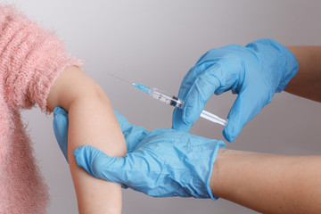 a little girl gets vaccinated on a white background in a Studio. vaccine, inoculation