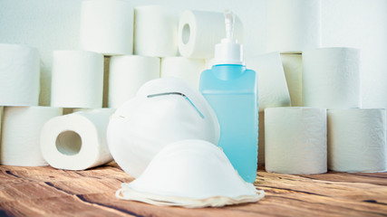 Many toilet paper rolls at home of hoarder with medical surgical masks and sanitizer hoarding amidst panic buying for corona virus outbreak shortage. Last stock of essential products for pandemic