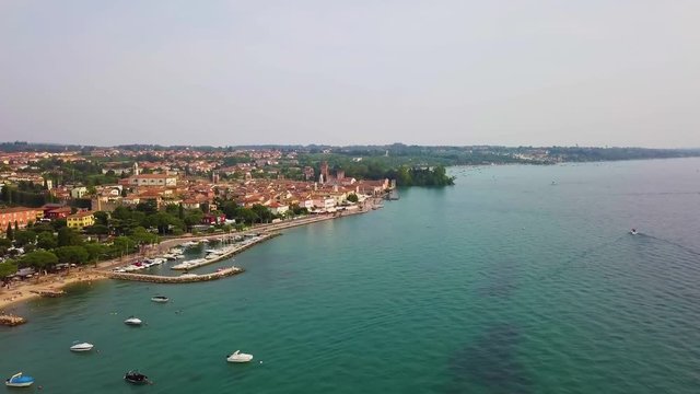 4K Aerial video with drone. Panoramic view of the resort town of Lazise on Lake Garda, north of Italy. Boat parking in the city.