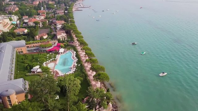 4K Aerial video with drone. Panoramic view of the resort town of Lazise on Lake Garda, north of Italy. Swimming pool