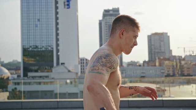 muscular man with tattoos exercising with nunchaku