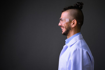 Closeup profile view of happy bearded Turkish man doctor as scientist smiling