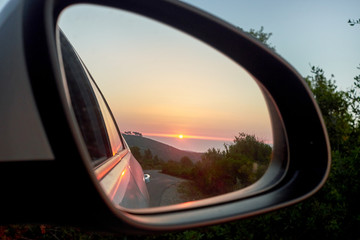 Sunset in the mirror of the car and sea