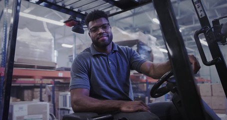 Manager in shipping warehouse using forklift