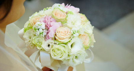 Bride in wedding dress holding flower bouquet 