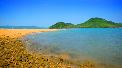 Tropical island bay, stone reef and mountain view background on summer season.
