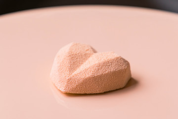 Close-up of confectioner decorates the cake with velour using the spray gun.