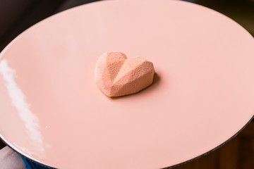 Close-up of confectioner decorates the cake with velour using the spray gun.