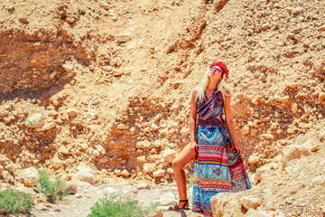 adorable smiling Ukrainian white girl portrait in dress and bare sexy legs in sunny bright desert canyon wilderness nature environment