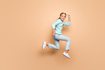 Fototapeta na wymiar Full body photo of pretty little girl in casual clothing running jumping up high isolated over pastel color beige background