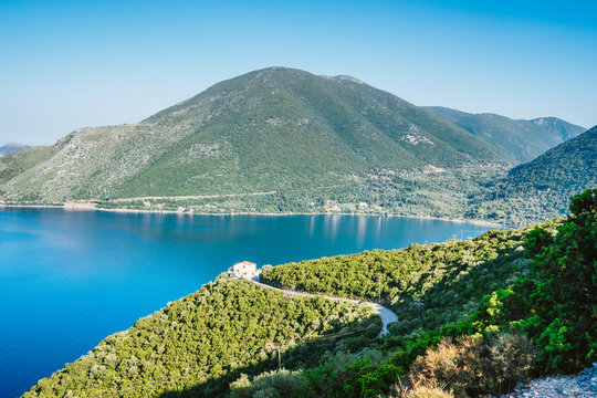 Crystal clear water, huge hills overgrown with cypresses, pine and olive trees. Stunning view of mediterranean coastline of Greece