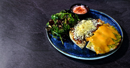 A nice breakfast plate with cheddar cheese, onion and tomato sauce