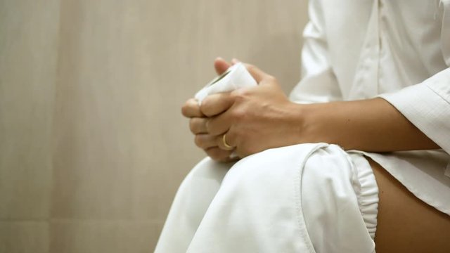 Young Asian woman suffering from constipation on toilet bowl at home. Health care concept.