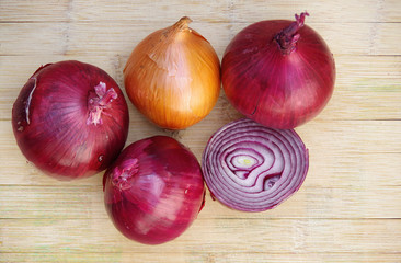 High angle close-up view from directly above of some organic yellow and red onions with one cut open