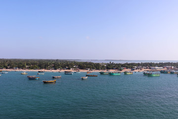 Fototapeta na wymiar Ships Fisherman Boats Parked At Harbor or Harbour In Sea Oocean With Blue Water And Greenery At Coast. Natural Scenery Or Landscape