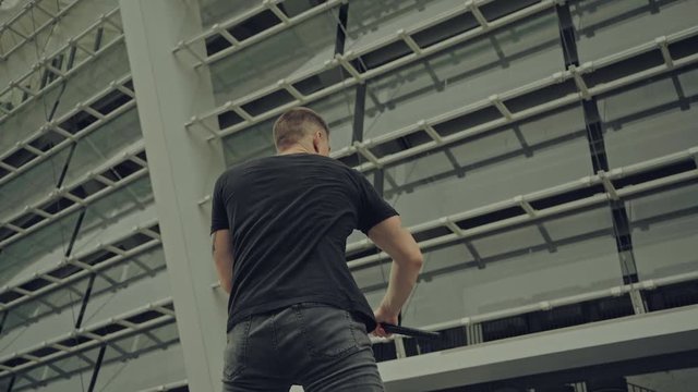 low angle view of tattooed man exercising with nunchaku