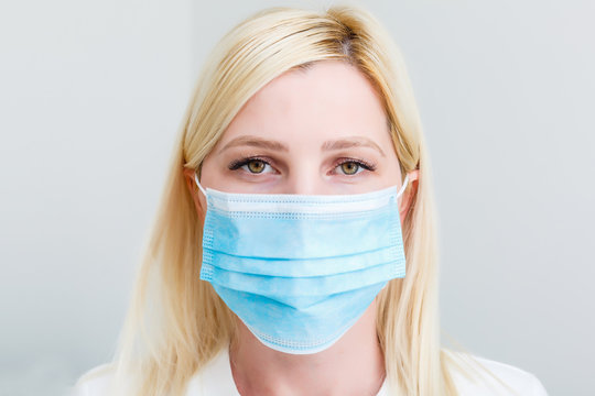 Woman With A Medical Mask For Protection Again Influenza. Shallow Depth Of Field. Copy Space For Your Text.