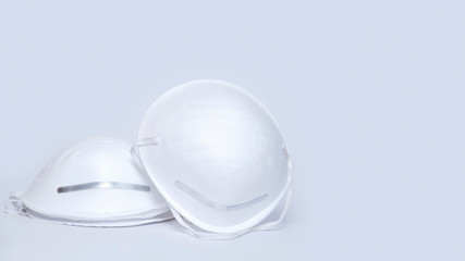 White paper medical protective mask isolated on light grey backdrop. Virus protection, medicine and health care concept. Front view, Copy space